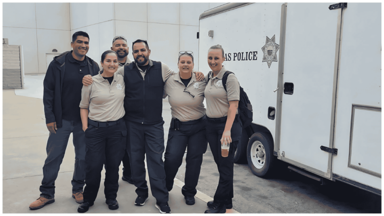Officers and staff standing in the back parking lot in front of the Salinas Police Department hauling trailer.