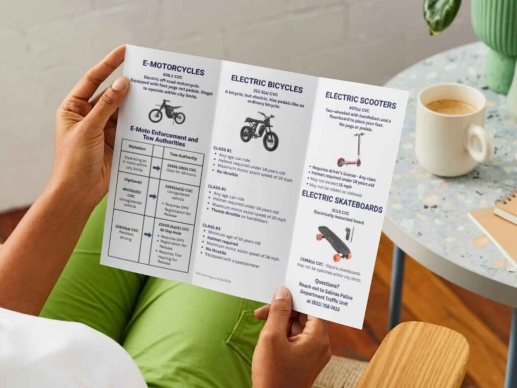 Person reading the E‑Moto, E‑Bike, E‑Scooter, and E‑Motorcycle Quick Reference Guide brochure.